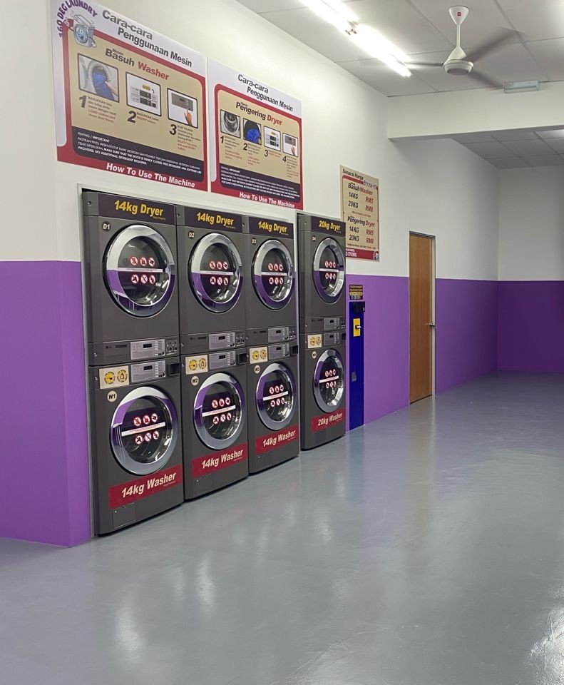Laundromat with purple wall trim and a row of stacked coin-operated machines